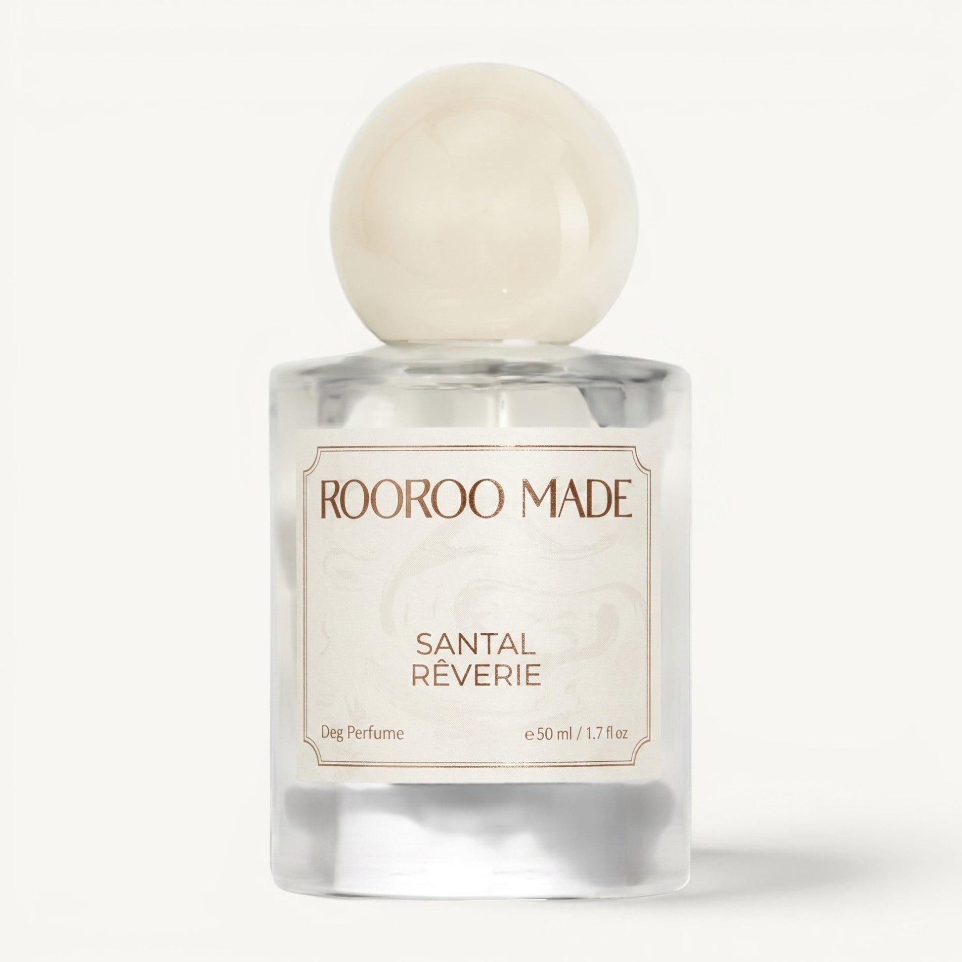 The Scented Canine Santal Rêverie luxury dog perfume in a clear glass bottle with a round cream cap.