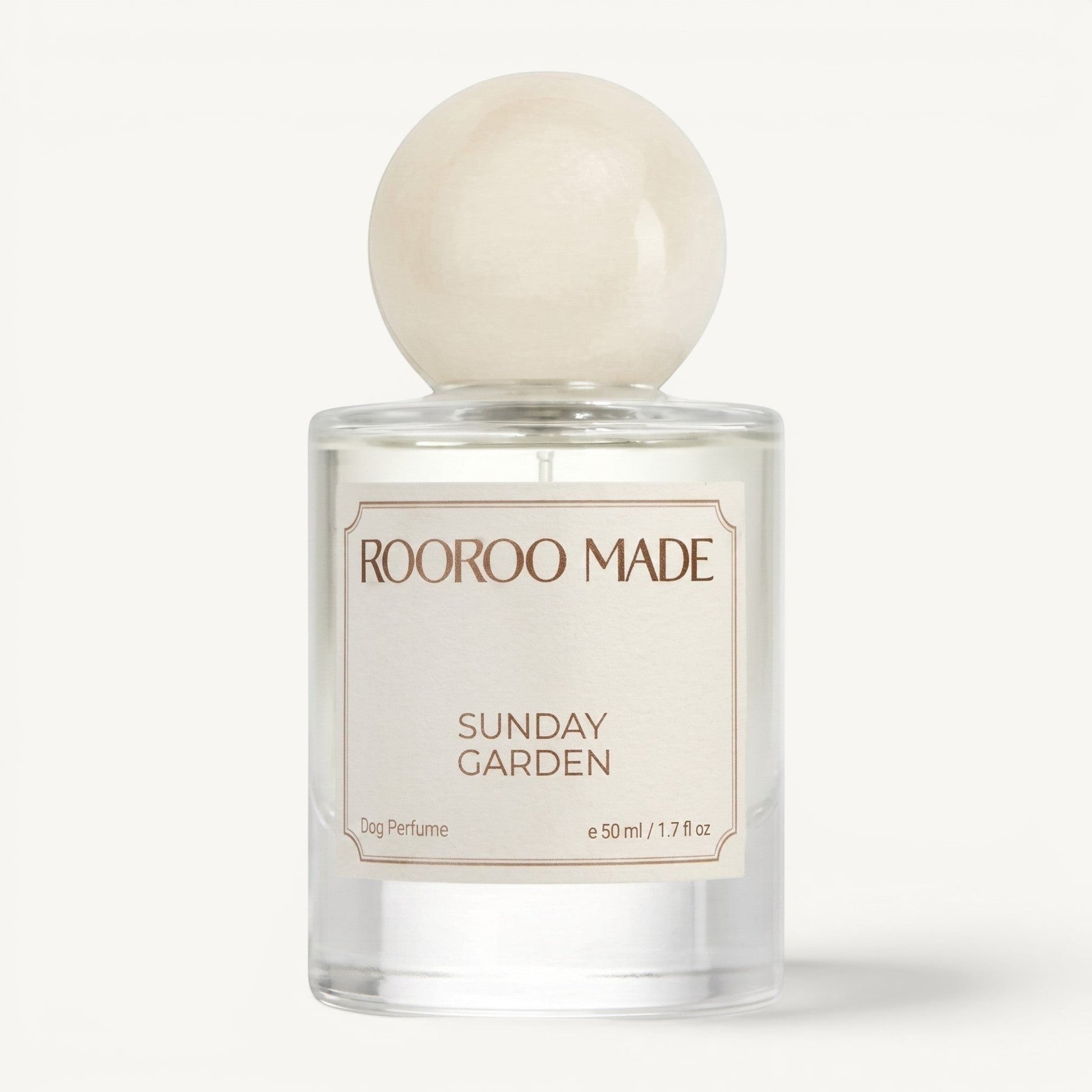 The Scented Canine Sunday Garden luxury dog perfume in a clear 50ml glass bottle with a round cream-colored cap.
